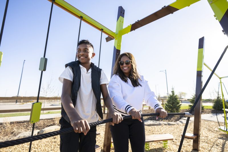 Family playing on playground in Chelsea, Chestermere community.